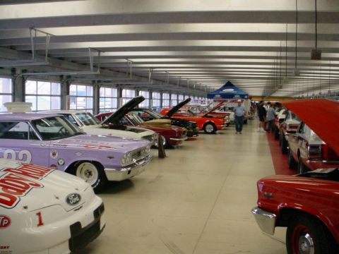 1972 Ford Ranchero - Several vintage cars are displayed indoors with their hoods open, suggesting a car show or exhibition.