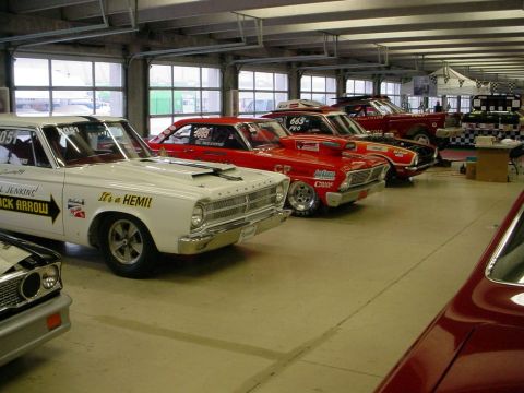 1972 Ford Ranchero - Several drag racing cars are lined up inside a garage, with a white Plymouth in the foreground.