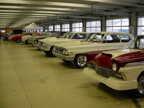 1972 Ford Ranchero - Several classic cars are parked in a garage, with a two-tone red and white vehicle in the foreground.