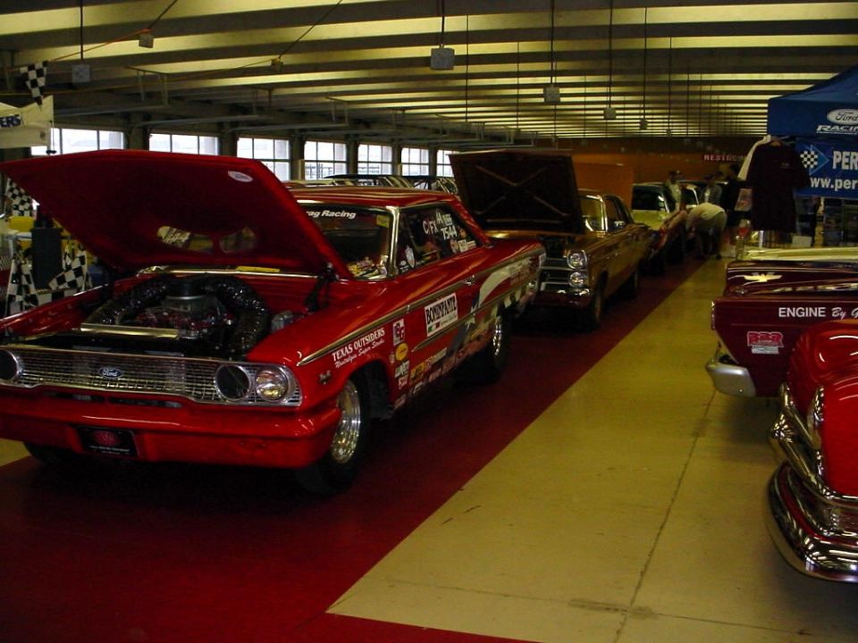 Red 1964 Ford sedan with hood open, racing decals on side