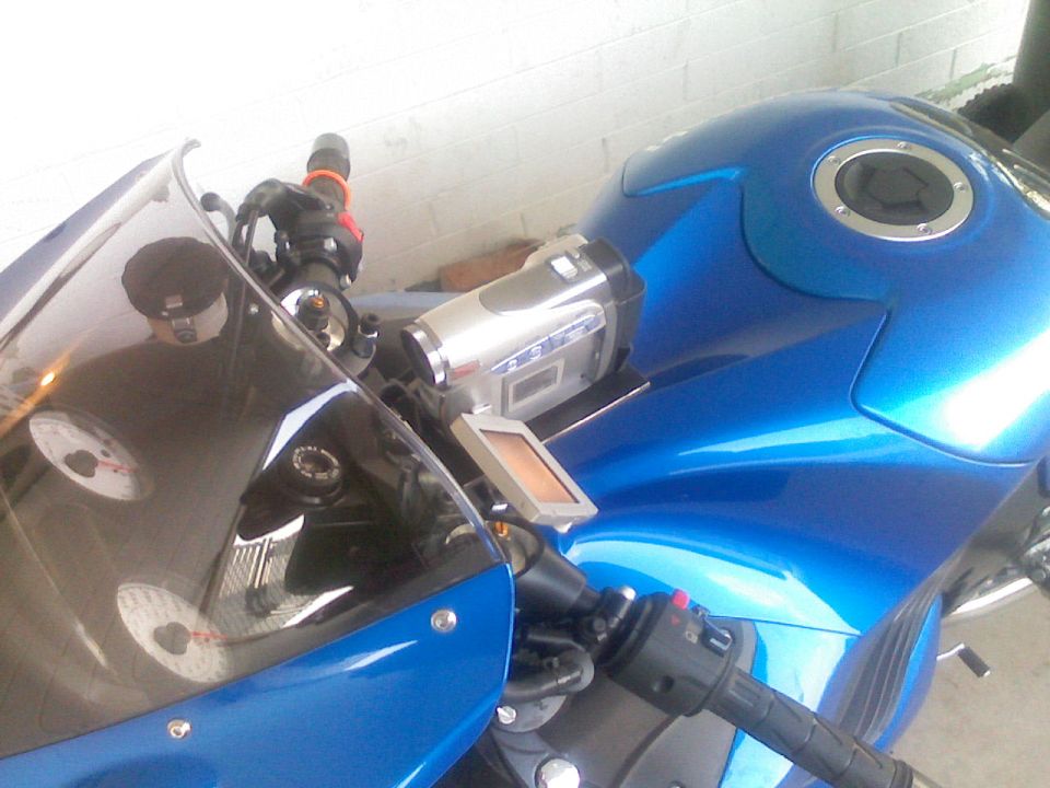 Blue motorcycle dashboard with a camcorder mounted on the handlebars