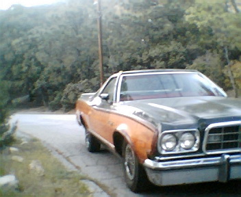 1973 Ford Ranchero - This 1973 Ford Ranchero is parked on a paved surface with trees in the background.