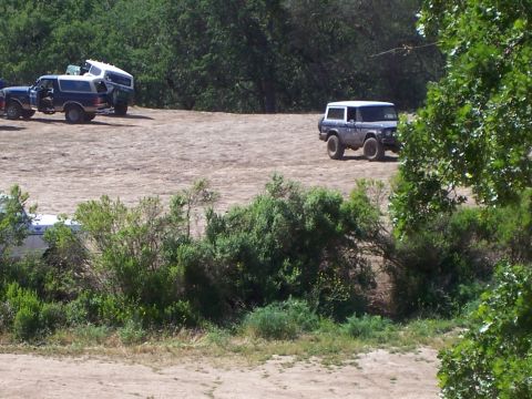 1991 Ford Bronco - Several Ford Broncos are parked on a dirt lot during an outdoor event.