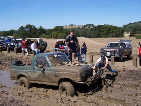 1991 Ford Bronco - Muddy 1991 Ford Bronco stuck in a mud pit during an off-road event.