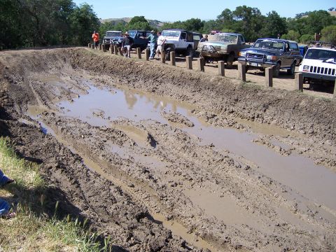 1991 Ford Bronco - Off-road vehicles gathered at a mud pit during an event.