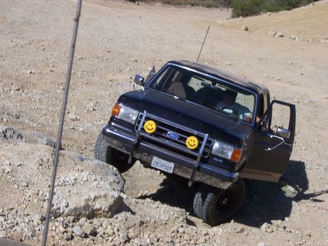 1991 Ford Bronco - 1991 Ford Bronco navigating rough terrain with its door open.