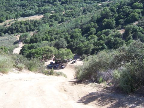 1991 Ford Bronco - Several off-road vehicles are gathered in a wooded area, likely during an outdoor event.
