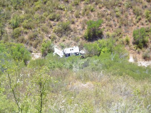 1992 Ford Explorer - A white truck has crashed and is overturned in a ditch surrounded by brush.