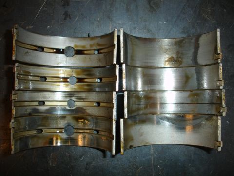 1992 Ford Taurus - Set of engine bearing shells showing wear and oil.