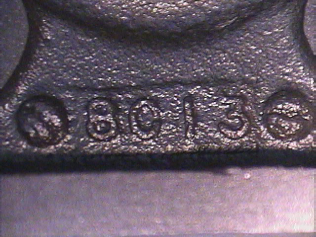 Close-up of an 8C13 casting date code on a bare cast-iron cylinder head