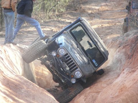 2004 Jeep Wrangler - Jeep Wrangler struggling on a challenging off-road trail, with spectators observing the difficult maneuver.