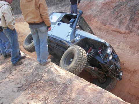 2004 Jeep Wrangler - A light blue 2004 Jeep Wrangler navigates a steep dirt incline during an off-road excursion.
