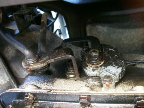 1984 Ford Bronco - This photo shows the linkage mechanism of a vehicle's transmission, with visible signs of wear and potential fluid leaks.