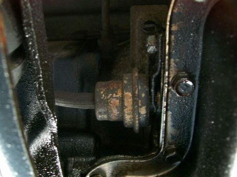 1984 Ford Bronco - Detail of a vehicle's transmission linkage and pan, showing signs of rust and wear.