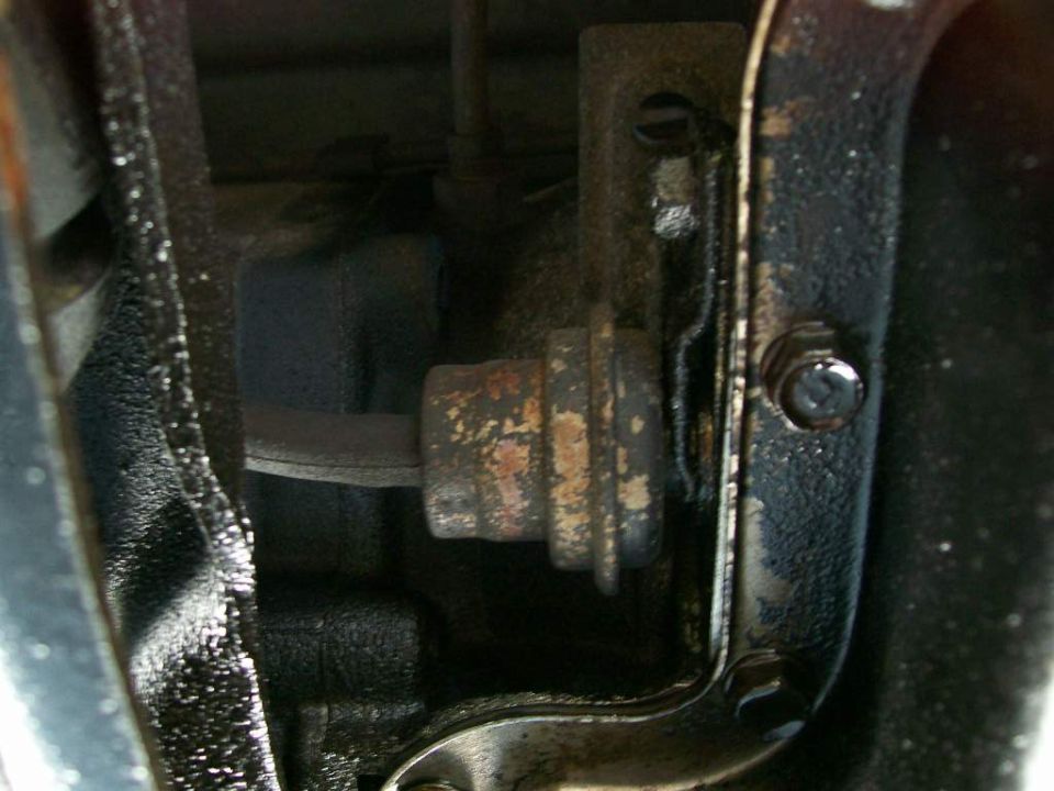 Rusty cylindrical vacuum modulator on greasy transmission housing