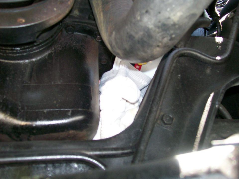 Engine oil filter and pan with white cloth underneath. Part number '2' visible on filter