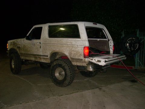 1992 Ford Bronco - This 1992 Ford Bronco is shown in a rear 3/4 view, lifted with off-road tires and its tailgate open.