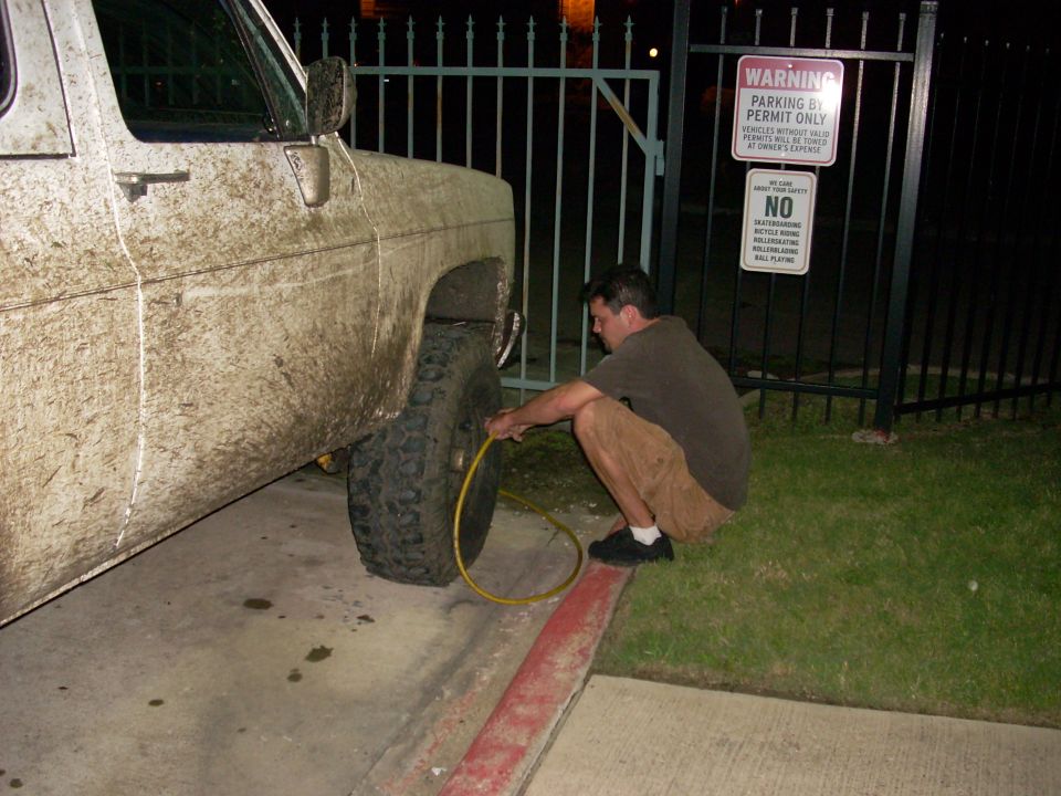 guy airing up tire on dirty truck