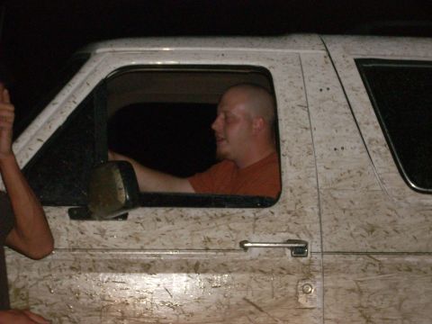 1992 Ford Bronco - A driver navigates a mud-covered vehicle at night, with a passenger's arm visible outside.