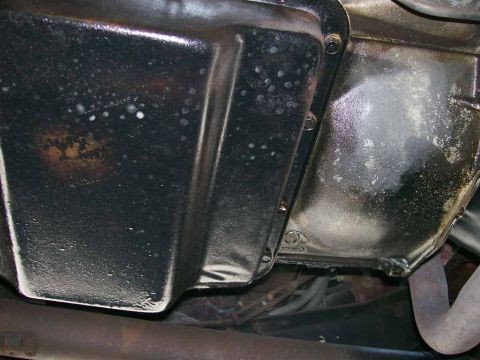 1984 Ford Bronco - Underside view of a transmission oil pan and associated components.