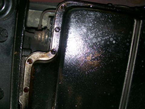 1984 Ford Bronco - Underside view of a vehicle's transmission pan and associated linkage components.