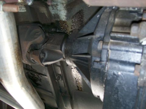 1984 Ford Bronco - Close-up of vehicle transfer case and driveshaft assembly, showing mechanical parts.