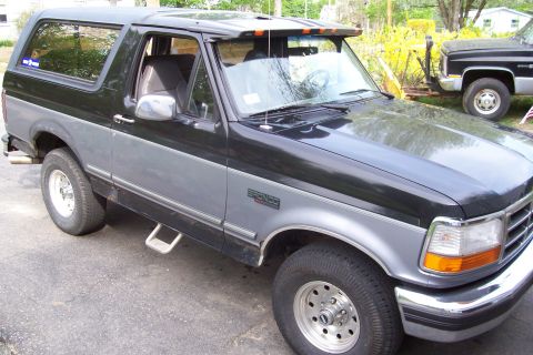 1995 Ford Bronco - This Ford Bronco SUV is shown from a three-quarter front angle, with another vehicle visible behind it.