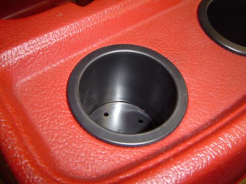 1989 Ford Bronco - Close-up of a red interior console two black cup holders, likely from a vehicle.