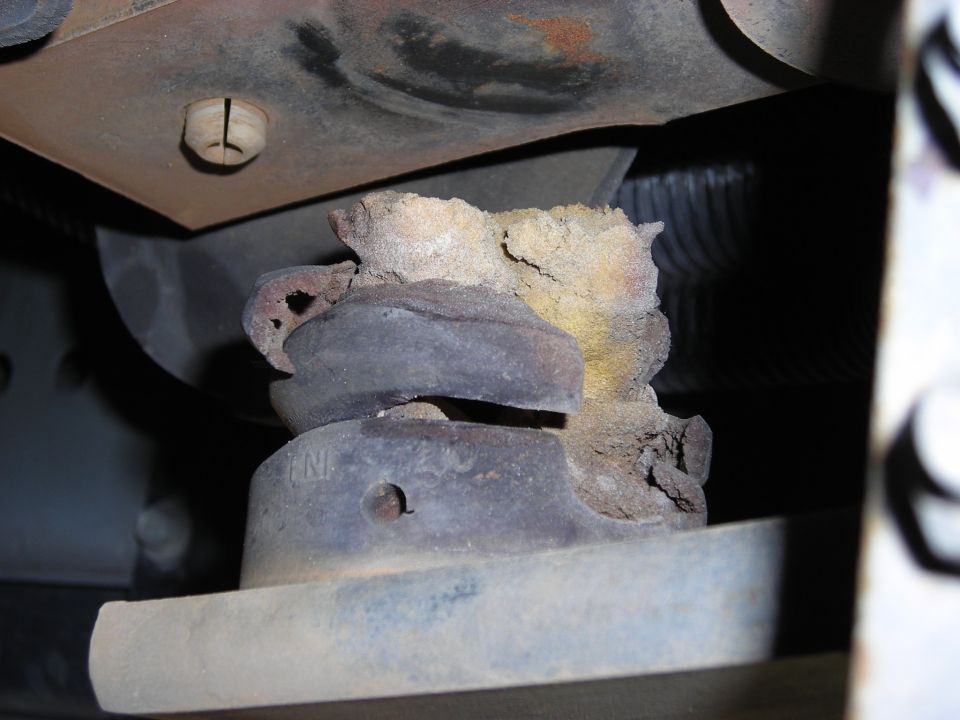 Cracked, crumbling rubber body/suspension mount seen from under a vehicle