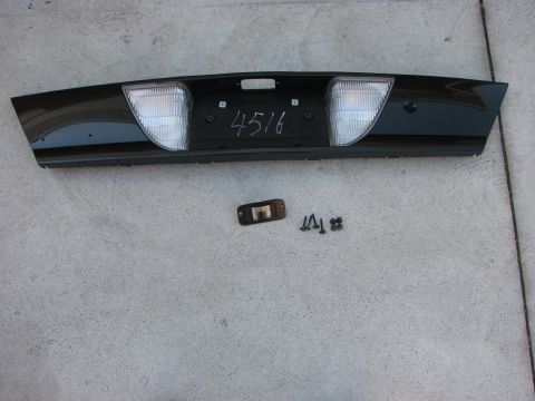 2003 Ford Crown Victoria - This black rear bumper trim panel features integrated lights and a handwritten number '4516' on its surface.