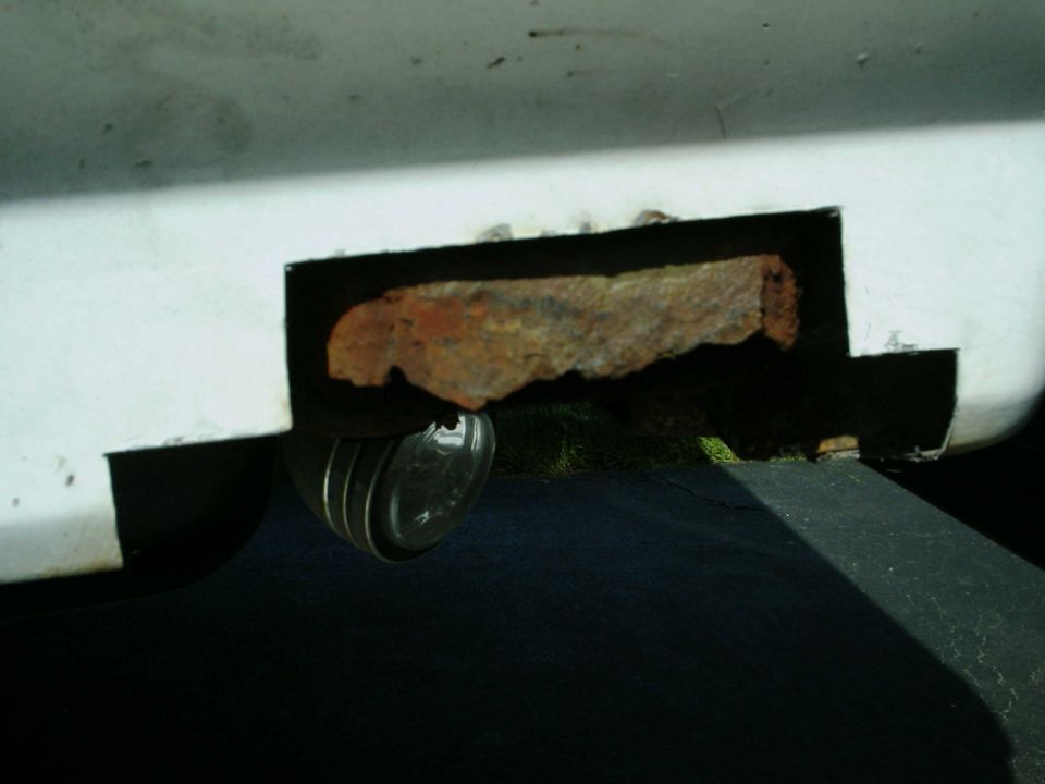 White vehicle panel with rust hole and a round light