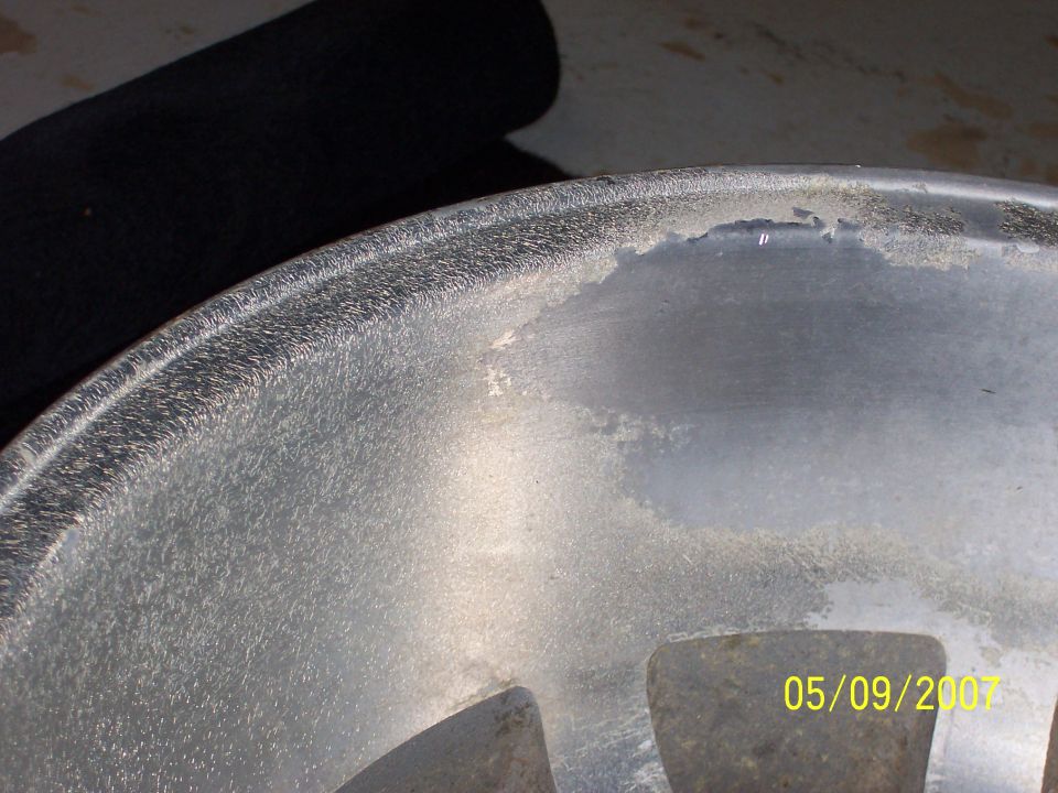 Close-up of corroded aluminum wheel rim with peeling clearcoat, dated 05/09/2007