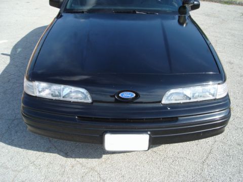 1992 Ford Crown Victoria - Front view of a black 1992 Ford Crown Victoria, displaying its distinctive grille and headlights.