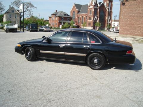 1992 Ford Crown Victoria - A black 1992 Ford Crown Victoria sedan is parked in a lot with a church in the background.