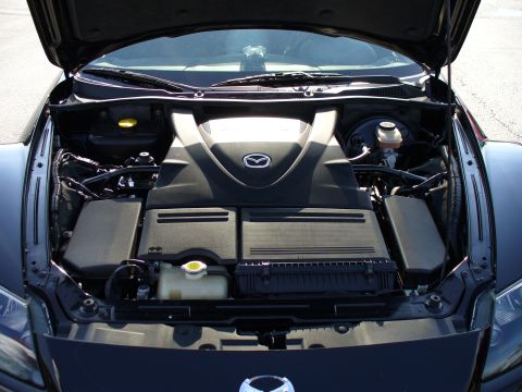1991 Ford Probe - The engine bay of a Mazda RX-8, its distinctive rotary engine cover and various fluid reservoirs.