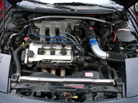 1991 Ford Probe - The engine bay of a 1991 Ford Probe shows its V6 engine with various aftermarket modifications.