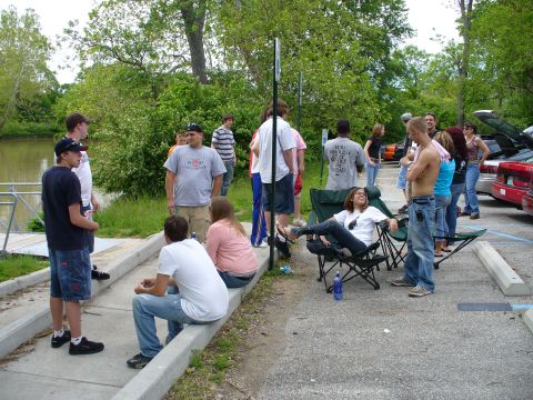 1991 Ford Probe - A group of people are socializing in an outdoor setting near a body of water.