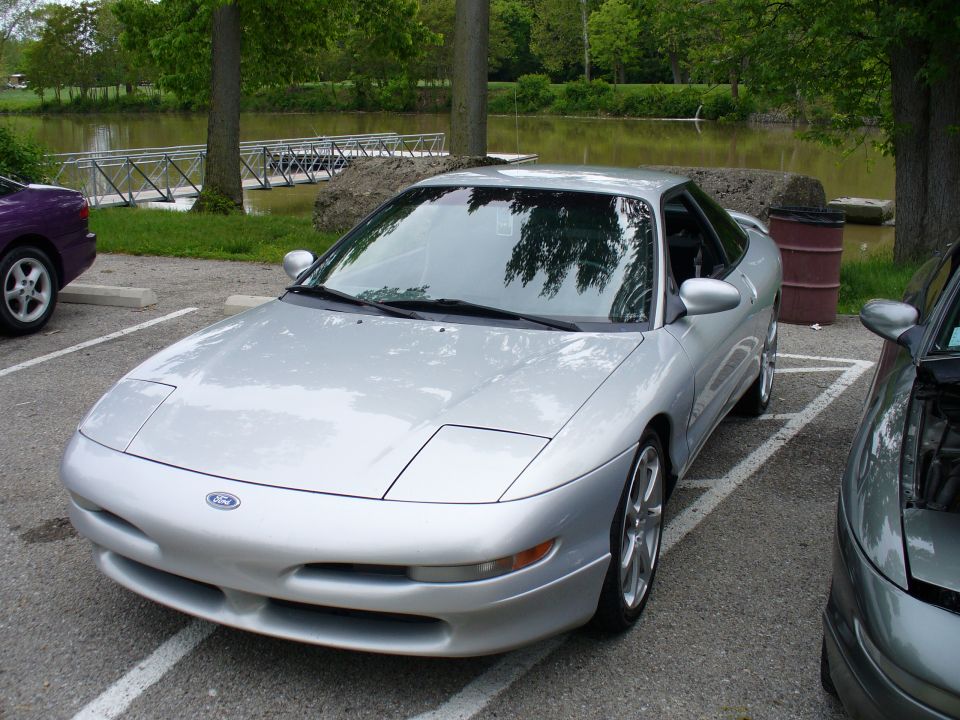 Silver 1991 Ford Probe parked next to a purple car and a gray car
