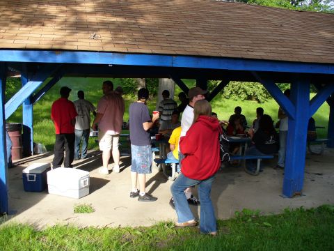 1991 Ford Probe - People are socializing under a covered picnic area on a sunny day.