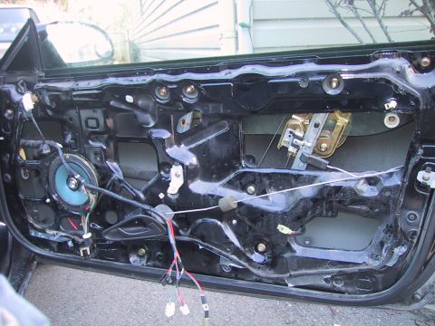 1993 Ford Probe - The interior of a car door is exposed, revealing the speaker and window mechanism.