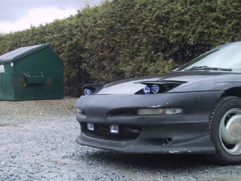 1993 Ford Probe - The front end of a 1993 Ford Probe is visible, pop-up headlights and an aftermarket bumper.