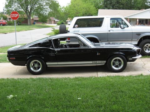 1968 Shelby GT500 - A black 1968 Shelby GT500 is parked on a driveway, with a silver Ford Bronco behind it.