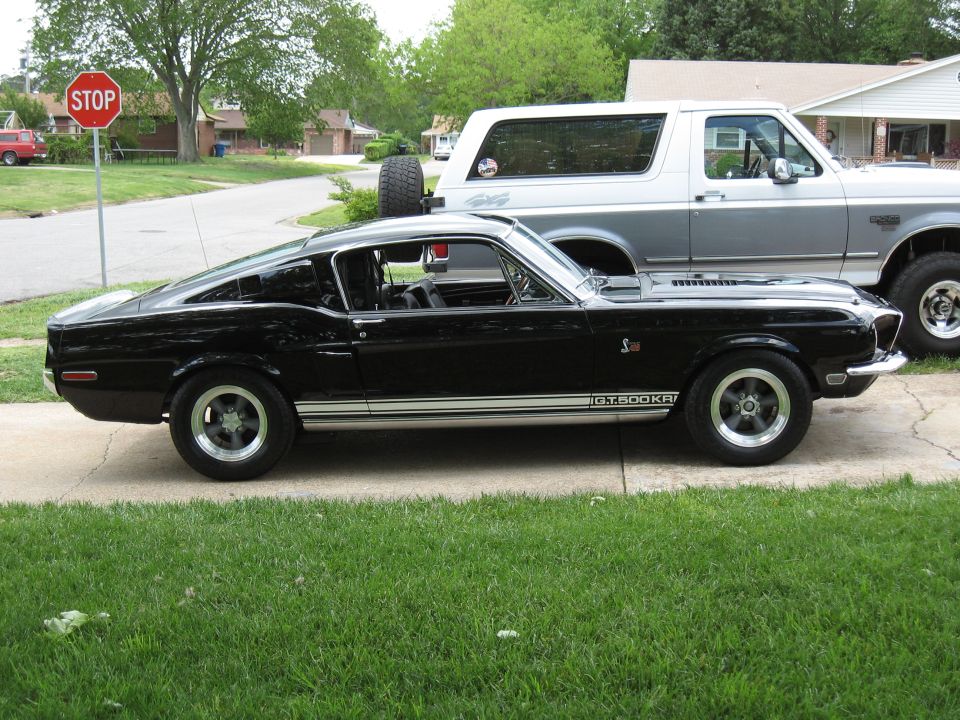 Black 1968 Shelby GT500 parked next to a silver Ford Bronco