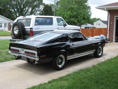 1968 Shelby GT500 - A black 1968 Shelby GT500 is parked in a driveway next to a Ford Bronco.