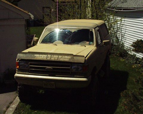1989 Ford Bronco - This 1989 Ford Bronco is parked in a residential area with a garage and house in the background.