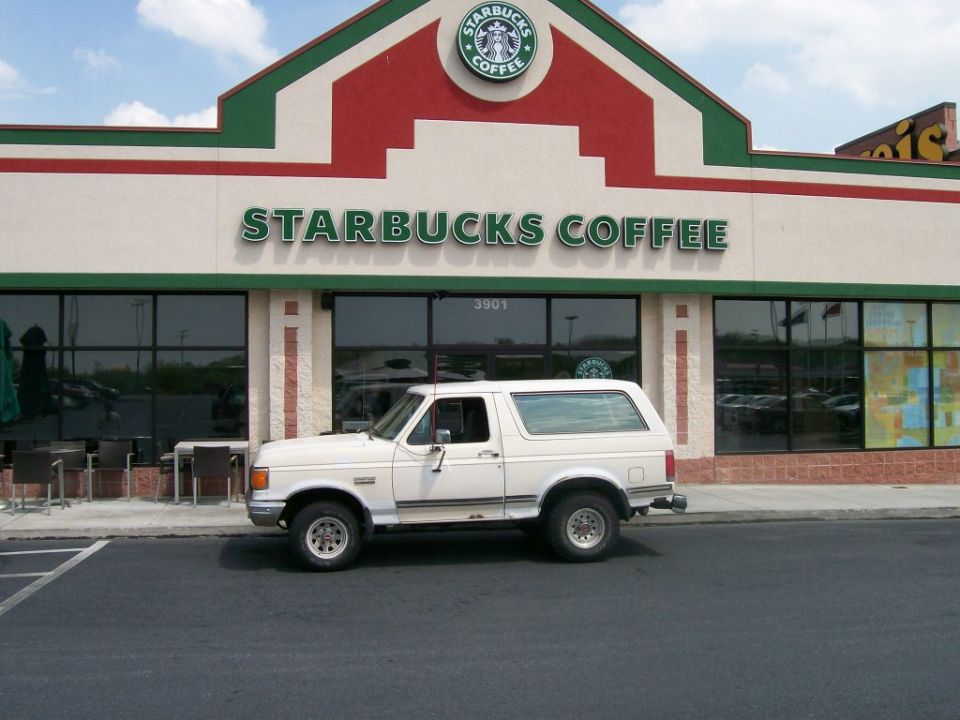 White 1987 Ford Bronco parked in front of Starbucks