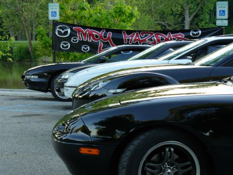 1991 Ford Probe - A row of Mazda vehicles is parked, with a club banner visible in the background.