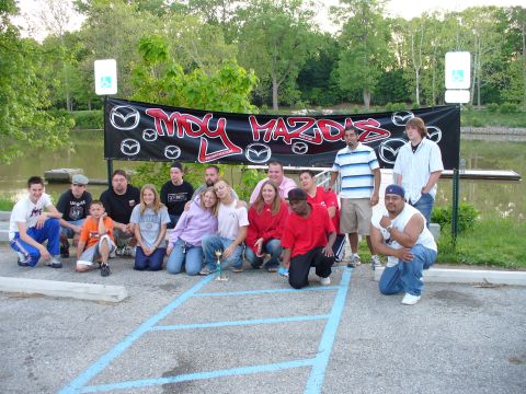 1991 Ford Probe - A group of people pose for a photo in front of a banner that reads "MDY MAZDAS".