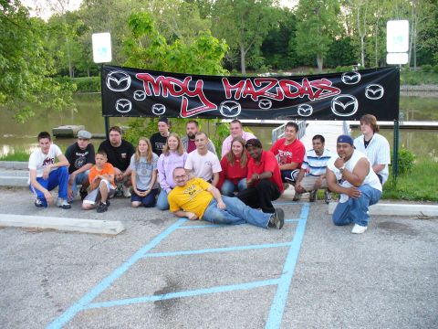 1991 Ford Probe - A group of people gathered for a photo in front of a Mazda-themed banner.