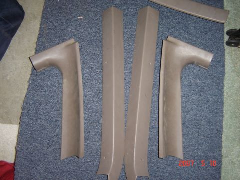 1993 Ford Bronco - Several tan interior trim pieces are laid out on a carpeted floor.